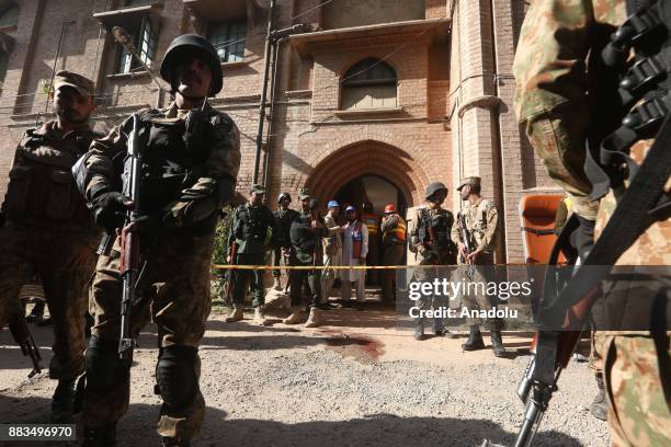 Pakistani army soldiers cordon off area inside Peshawar Agricultural Training Institute which was attacked by Taliban militants, in the northwestern...