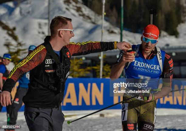 Ein Betreuer ueberreicht Arnd Peiffer ein Getraenk beim Laufen waehrend dem 20km Einzelrennen der Herren bei der IBU Biathlon Weltmeisterschaft am...