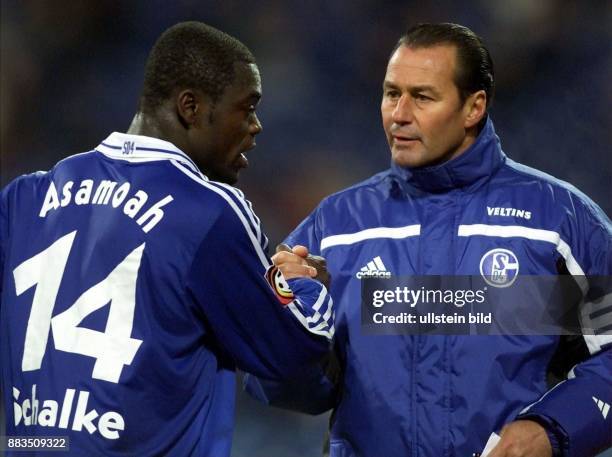 Gerald Asamoah , Stürmer beim Fußball-Bundesligisten FC Schalke 04, und sein Trainer Huub Stevens fassen sich an den Händen. .