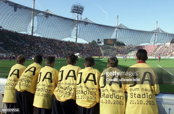 München, Bayern, D: das vollbesetzte Olympiastadion während des Bundesligaspiels am . Im Vordergrund sieben junge Männer in gelben T-Shirts mit der...