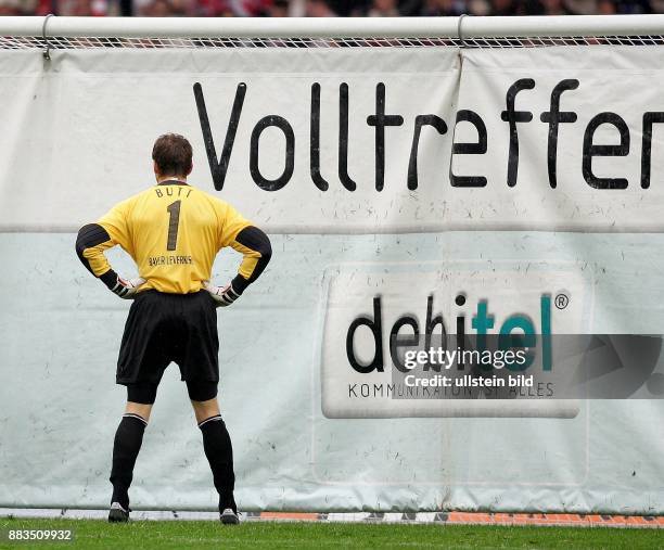 Hans-Joerg Butt Torhueter Bayer 04 Leverkusen; D steht vor dem mit einem Werbebanner von Debitel verhaengten Tor. Ganzkoerperaufnahme