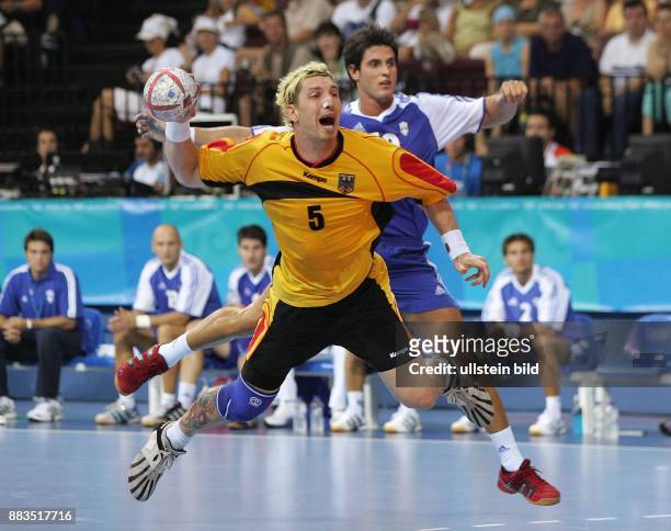 Olympische Spiele 2004 Athen - Handball, Deutschland 18 - Stephan Kretzschmar wirft, im Hintergrund Alexis Alvanos
