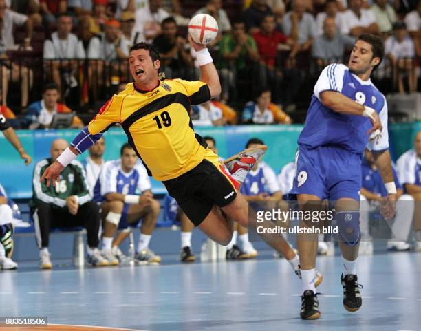 Olympische Spiele 2004 Athen - Handball, Deutschland 18 - Florian Kehrmann wirft, beobachtet vom Griechen Spyros Balomenos