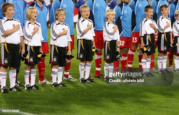 Deutschland, Mecklenburg-Vorpommern, Rostock: Länderspiel Deutschland 0 - Kinder der Fußballeskorte beim Singen der Nationalhymne