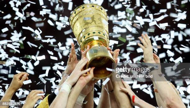 Haende greifen an den DFB-Pokal im Konfettiregen -