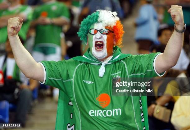 Fussball-WM 2002 Ein irischer Fan mit Gesichtsbemalung, Perücke und Spaßbrille ballt die Fäuste und schreit.