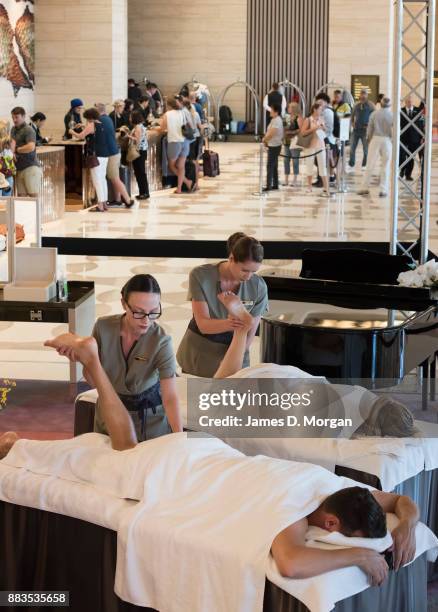 Bec Ormond and Mike Pinker having massages inside a live art installation in the hotel lobby of Crown Towers Perth on December 1, 2017 in Perth,...