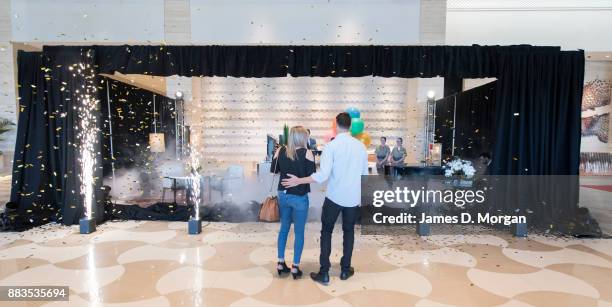 Bec Ormond and Mike Pinker watch as a curtain drops to reveal a live art installation in the hotel lobby of Crown Towers Perth on December 1, 2017 in...