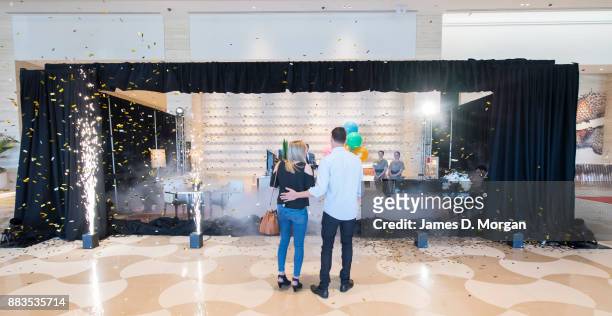 Bec Ormond and Mike Pinker watch as a curtain drops to reveal a live art installation in the hotel lobby of Crown Towers Perth on December 1, 2017 in...