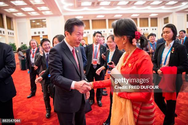 Myanmar's civilian leader Aung San Suu Kyi shakes hands with Natsuo Yamaguchi , president of New Komeito Party of Japan, as they attend the opening...