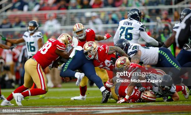 Ronald Blair III and Cassius Marsh of the San Francisco 49ers tackle Eddie Lacy of the Seattle Seahawks during the game at Levi's Stadium on November...