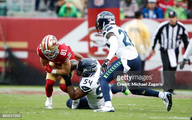 Bobby Wagner of the Seattle Seahawks strips the ball form Trent Taylor of the San Francisco 49ers during the game at Levi's Stadium on November 26,...