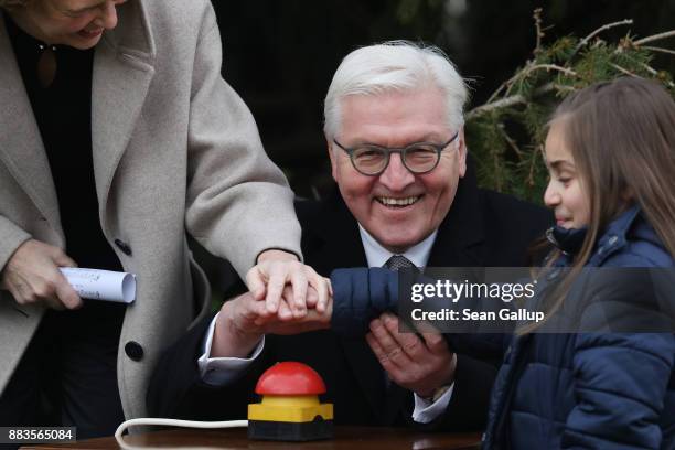 German President Frank-Walter Steinmeier and First Lady Elke Buendenbender, together with a child from a visiting group of children, press the button...