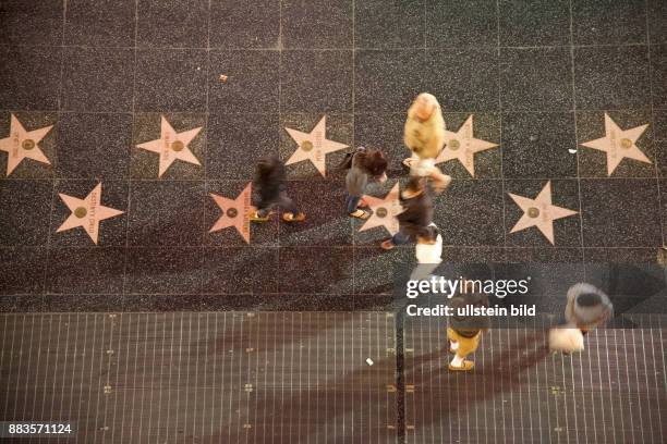 Passers-by walking at the Hollywood Boulevard, from a bird's eye view, with motion blur.