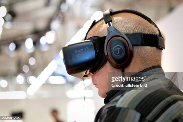 Virtual and augmented reality at the Photokina in Cologne: Man with a virtual reality Head-Mounted Display.