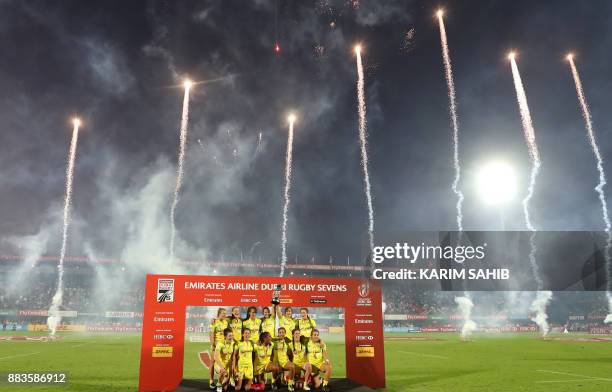 Members of Australia's women's national rugby sevens team lift the trophy as they celebrate their victory, after defeating the United States in the...