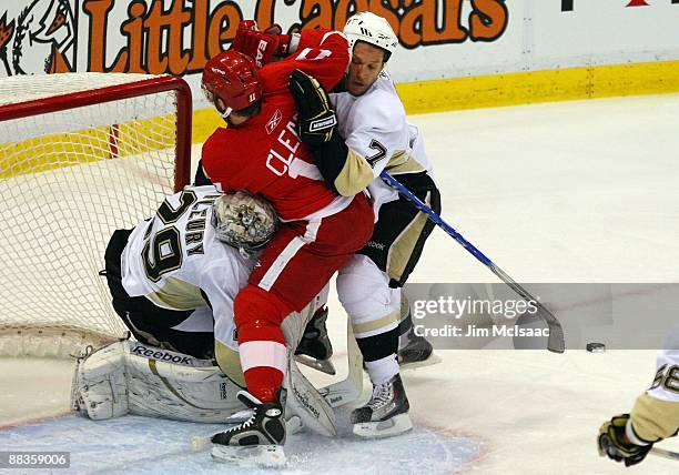 Dan Cleary of the Detroit Red Wings takes a shot against Mark Eaton and goaltender Marc-Andre Fleury of the Pittsburgh Penguins during Game Five of...