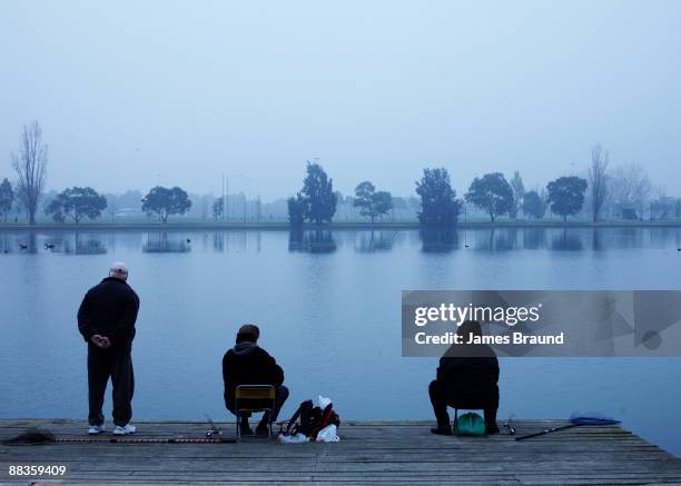 three men two sitting one standing - albert park lake stock pictures, royalty-free photos & images