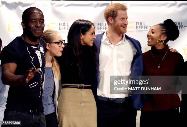 Britain's Prince Harry and his fiancee US actress Meghan Markle pose for a photograph with the cast and crew of a hip hop opera performed by young...