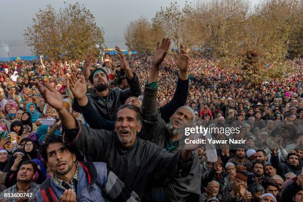 Kashmiri Muslim devotees look towards a cleric displaying the holy relic believed to be the whisker from the beard of the Prophet Mohammed, at...