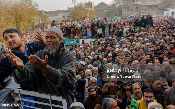 Kashmiri Muslim devotees look towards a cleric displaying the holy relic believed to be the whisker from the beard of the Prophet Mohammed, at...