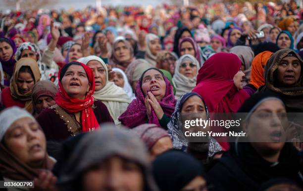 Kashmiri Muslim women devotees look towards a cleric displaying the holy relic believed to be the whisker from the beard of the Prophet Mohammed, at...