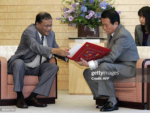 Bangladesh Foreign Affairs Minister Hasan Mahmud presents a letter to Japanese Prime Minister Taro Aso during their meeting at the latter's official...