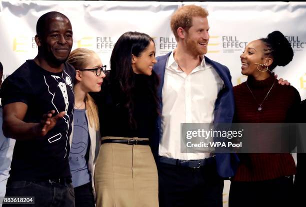 Prince Harry and his fiancee US actress Meghan Markle pose for a photograph with the cast and crew of a hip hop opera performed by young people...