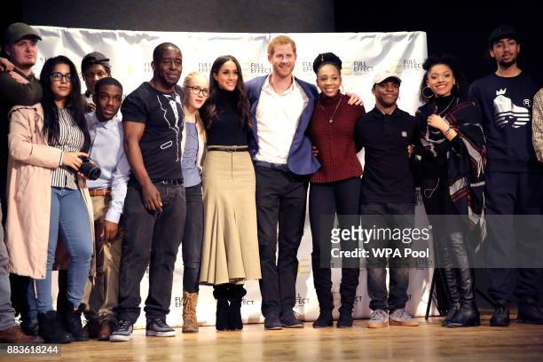 Prince Harry and his fiancee US actress Meghan Markle pose for a photograph with the cast and crew of a hip hop opera performed by young people...