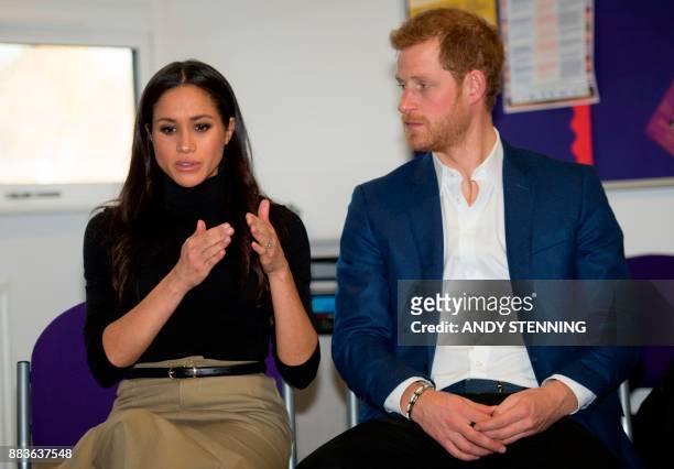 Britain's Prince Harry and his fiancee, US actress Meghan Markle gesture during their visit to Nottingham Academy in Nottingham, central England, on...