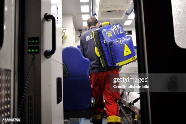 Sanitäter der Berliner Feuerwehr mit seinem Notfallrucksack auf dem Rettungswagen