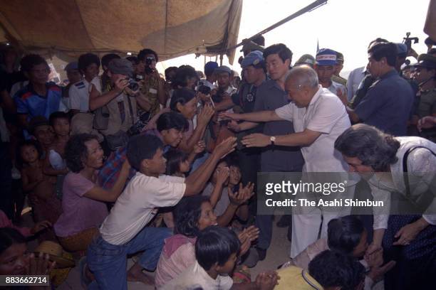 Prince Norodom Sihanouk of Cambodia welcomes Cambodian refugees returning from Thailand on March 30, 1992 in Sisophone, Cambodia.