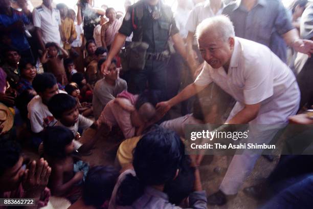 Prince Norodom Sihanouk of Cambodia welcomes Cambodian refugees returning from Thailand on March 30, 1992 in Sisophone, Cambodia.