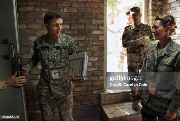 Maj. General Michael T. Flynn, director of intelligence in Afghanistan, holds the door on the way to the command center, where the morning briefing...