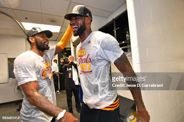 Kyrie Irving and LeBron James of the Cleveland Cavaliers hug and celebrate in the locker room after winning Game Five of the Eastern Conference...