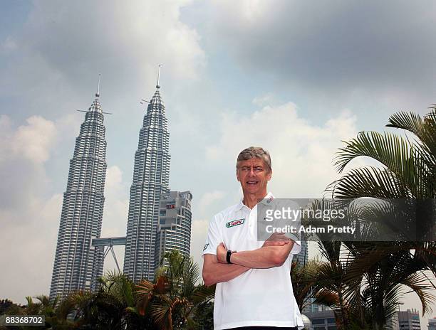 Arsene Wenger poses for a portrait in front of Kuala Lumpurs landmark twin towersbefore taking the Malaysian youth team through the Castrol Challenge...