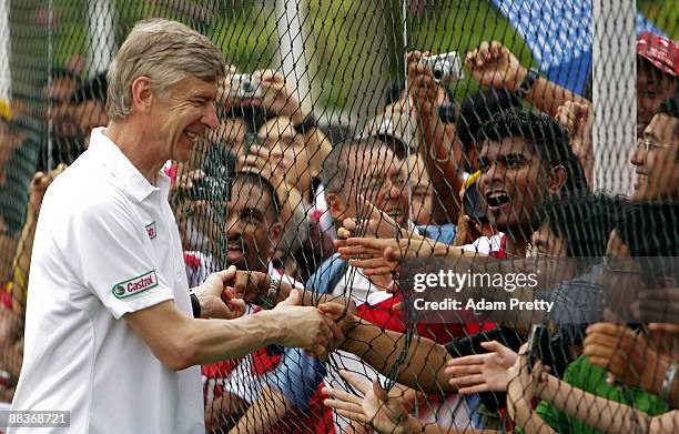 Arsene Wenger meets the fans before taking the Malaysian youth team through the Castrol Challenge at the Dataran Merdeka Square during his tour of...