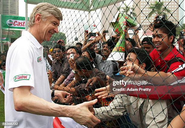 Arsene Wenger meets the fans before taking the Malaysian youth team through the Castrol Challenge at the Dataran Merdeka Square during his tour of...