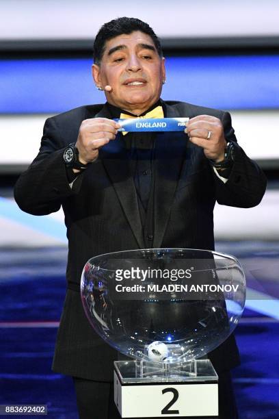 Argentina's former midfielder Diego Maradona displays the slip of England during the Final Draw for the 2018 FIFA World Cup football tournament at...