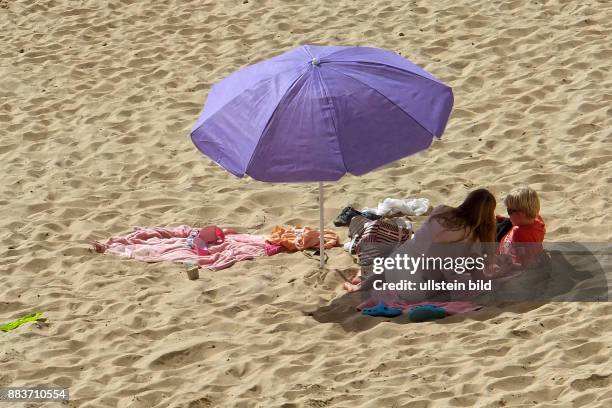 Sonnenbaden am Strand - Hintergrund das Hotel RIU Palace - gesehen in Jandia auf Fuerteventura-Süd