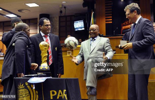 South African President, Jacob Zuma, kicks a soccer ball, given to him by FIFA Secretary-General Jérôme Valcke, in the South African Parliament, on...