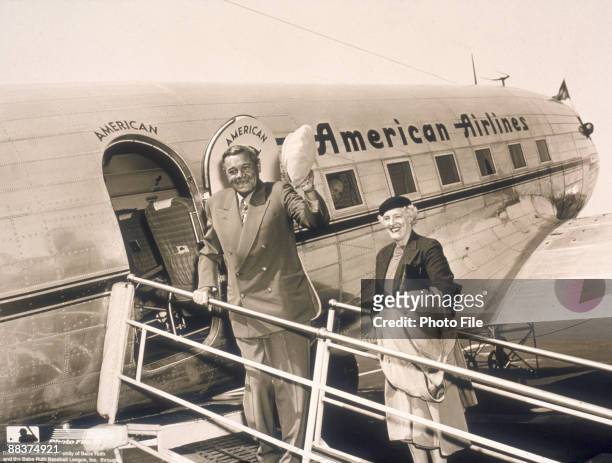 American baseball player George Herman 'Babe' Ruth waves his hat as his wife, Claire Merritt Hodgson, smikes beside him on the gangwy of an American...