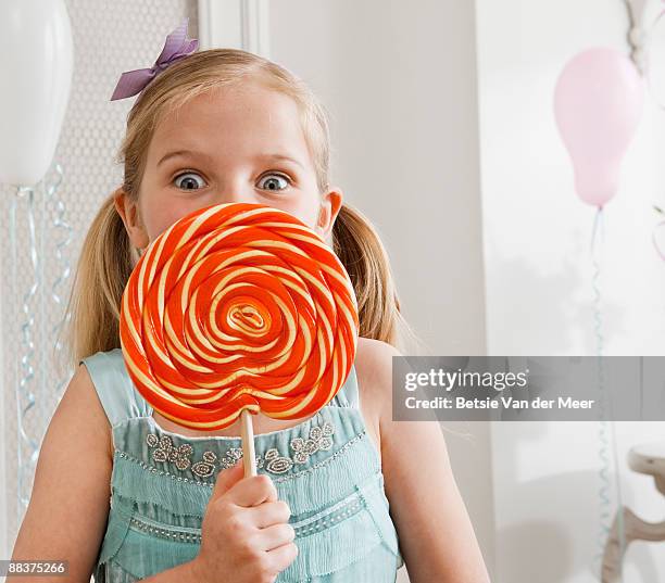 girl holding large lollipop. - lollipop fotografías e imágenes de stock