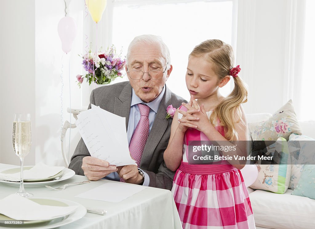 Grandad practising speech with granddaughter.