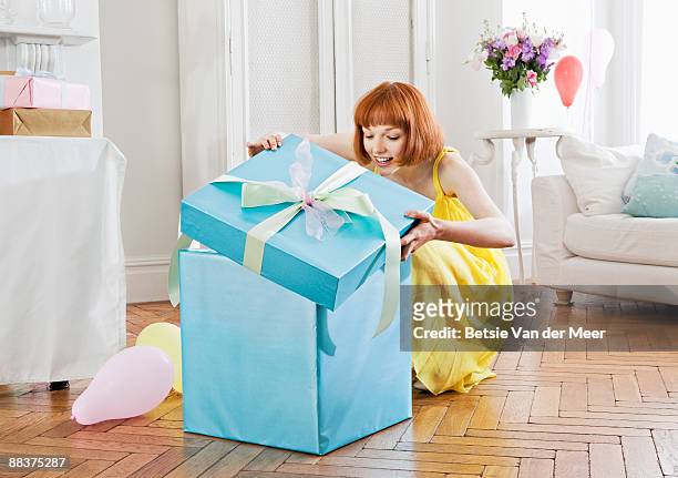 woman opening large present. - woman with gift stock pictures, royalty-free photos & images