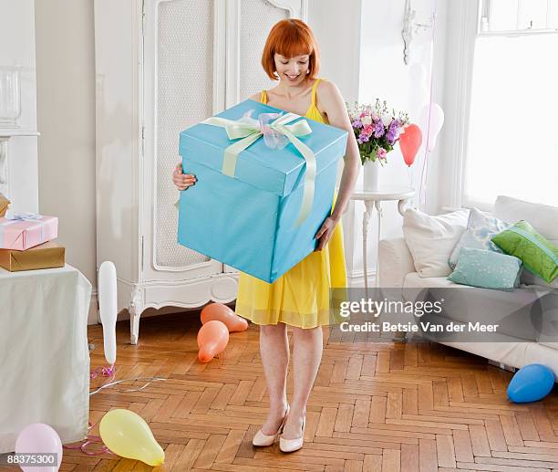 woman holding large present. - sorpresa regalo foto e immagini stock