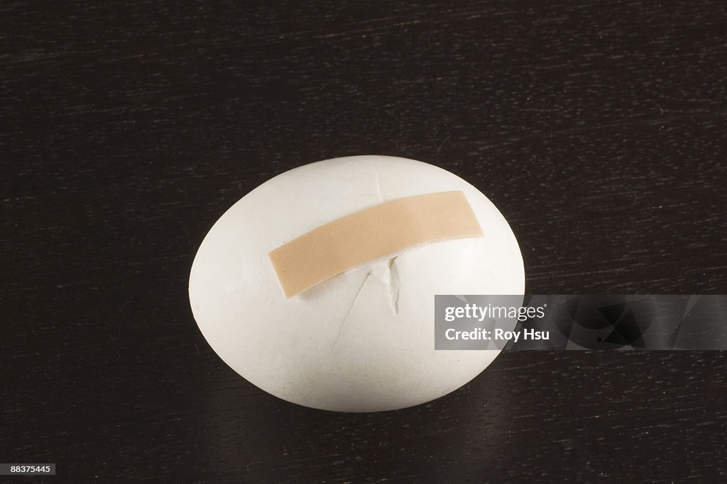 Cracked egg with bandaid