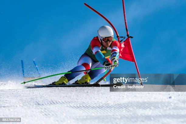 vista frontale dello sciatore alpino professionista che gareggia nella gara di slalom gigante - ski foto e immagini stock
