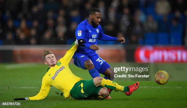 Norwich player James Maddison challenges Junior Hoilett of Cardiff during the Sky Bet Championship match between Cardiff City and Norwich City at...