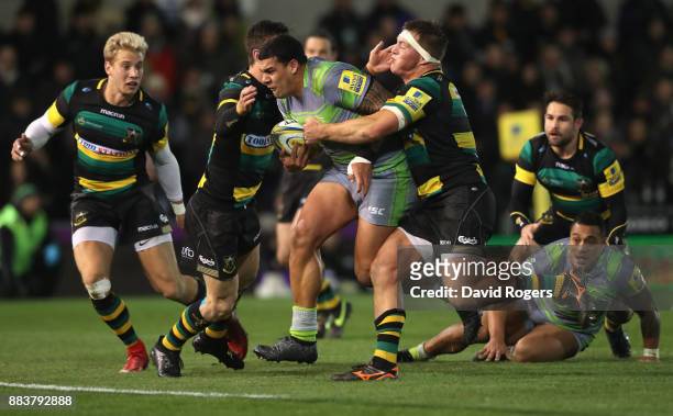 Josh Matavesi of Newcastle holds off Rob Horne and Alex Waller to score their second try during the Aviva Premiership match between Northampton...